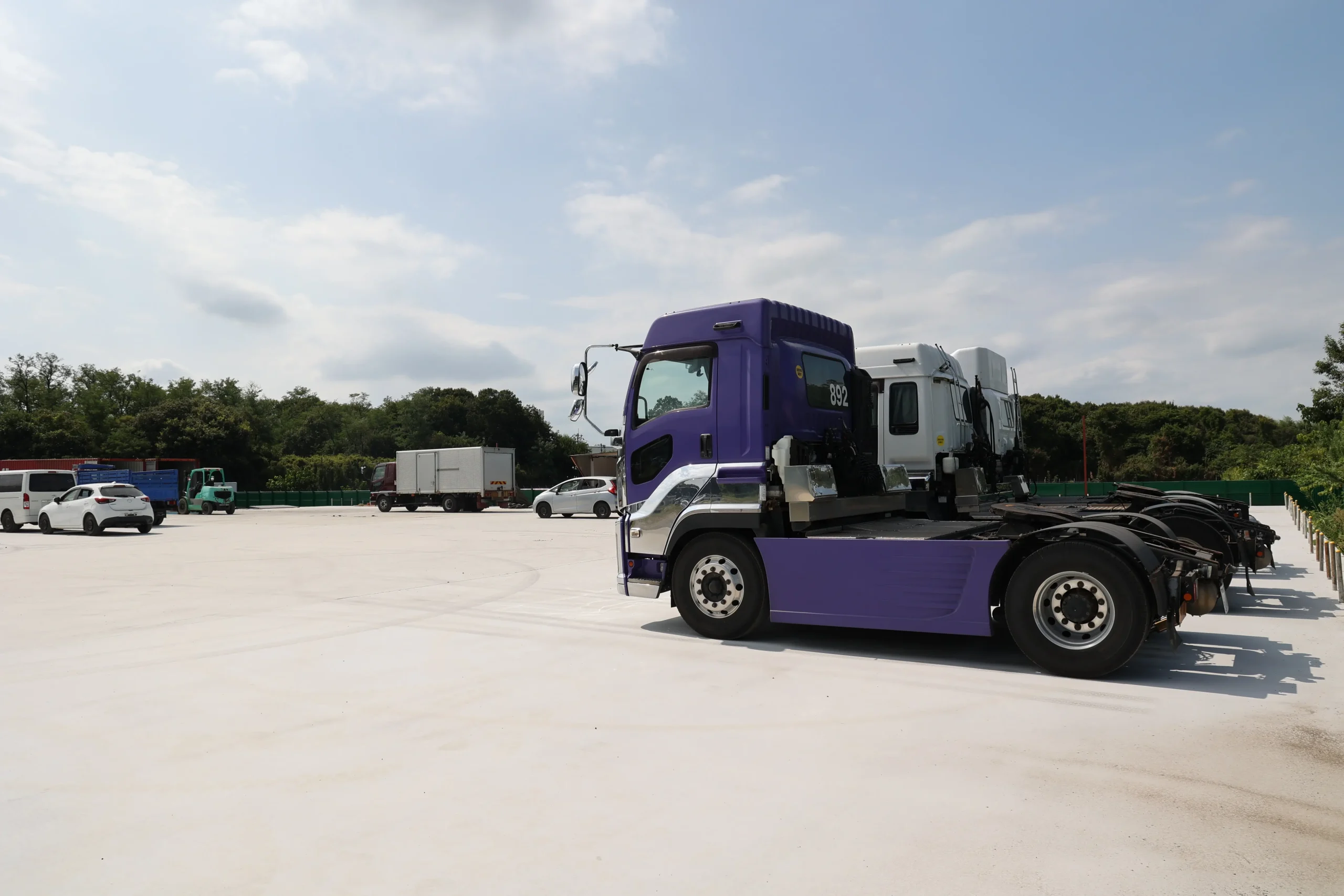 Fleet of transport trucks in a logistics terminal, showcasing ground operations for freight forwarding services in Japan.